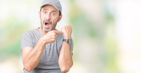 Handsome middle age hoary senior man wearing sport cap over isolated background In hurry pointing to watch time, impatience, upset and angry for deadline delay
