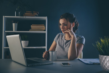 Stressed woman in office working on the computer. Headache concept