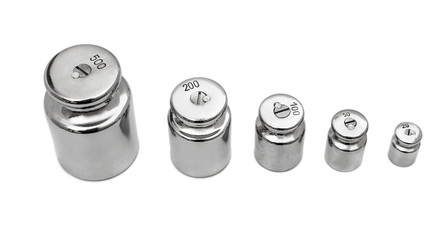 Row of weights for laboratory scales on white.