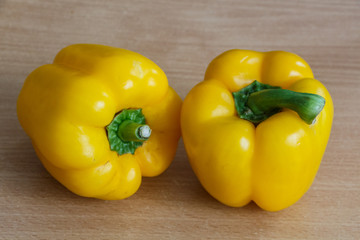 Two whole yellow peppers on a table
