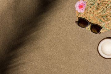 Fototapeta na wymiar Minimalist summer flat lay with, sunglasses, panama hat and palm leaves shadow on sand background..