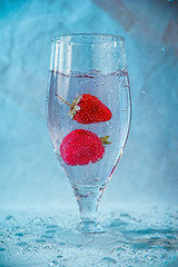 fresh strawberries in water with splashes and bubbles