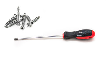Shiny metal screwdriver for repair with a plastic black and red handle and Screws still life large self tapping, the concept of manual labor and repair. Red screwdriver isolated on white background.