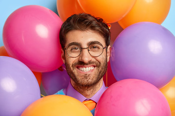 Birthday and celebration concept. Close up portrait of smiling man with bristle, wears spectacles...