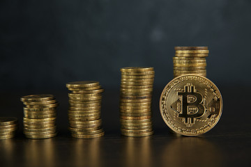 Stacks of bitcoins standing against a dark background .