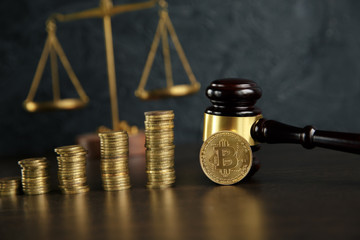 Auction gavel and bitcoin cryptocurrency money on a wooden desk, close-up. Law Gavel and golden bitcoin symbol on white background with copyspace