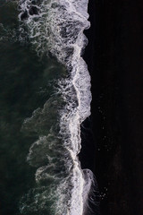 Overhead view of scenic sea waves on black sand beach in Iceland