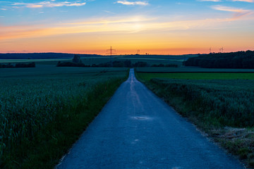 Empty straight road in rural landscape with evening sky. Hope concept