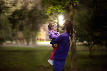 dad and daughter,with dreadlocks walking in the Park