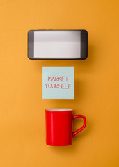 Word writing text Market Yourself. Business photo showcasing Making yourself for any kind of task and project in life Coffee cup colored sticky note electronic device yolk color background