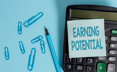 Writing note showing Earning Potential. Business concept for Top salary for a particular field or professional job Electronic calculator blank sticky note clips marker colored background