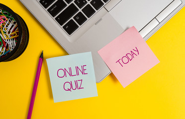 Text sign showing Online Quiz. Business photo text game or a mind sport that are published on the Internet Trendy metallic laptop sticky notes clips container pencil colored background