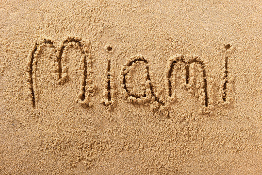 Miami word written in sand sign writing drawing drawn on a sunny florida summer beach holiday vacation travel destination message photo