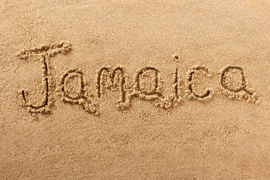 Jamaica word written in sand sign writing drawing drawn on a sunny summer beach holiday vacation travel destination message photo