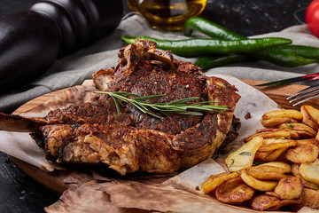 Tomahawk steak with vegetables and a knife on the table. Grilled meat with grilled vegetables and...