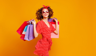 concept of shopping purchases and sales of happy   girl with packages  on yellow background.