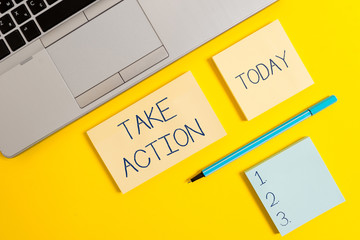 Conceptual hand writing showing Take Action. Concept meaning to do somethingoract in order to get a particular result Silver laptop square sticky notepads marker colored background