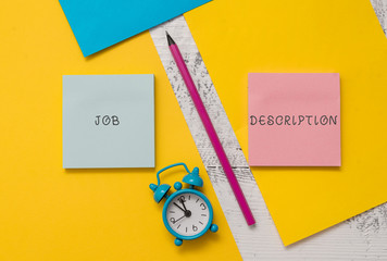 Text sign showing Job Description. Business photo text a formal account of an employee s is responsibilities Notepads marker pen colored paper sheets alarm clock wooden background