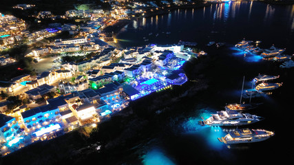 Aerial drone night shot of famous Psarou beach with luxury resorts and yachts docked, Mykonos...