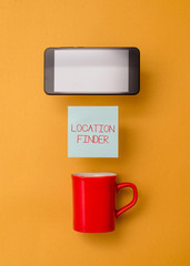 Word writing text Location Finder. Business photo showcasing A service featured to find the address of a selected place Coffee cup colored sticky note electronic device yolk color background
