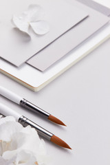 light grey flatlay top view light grey paper envelope notbook flatlay wedding invitation feminine minimalistic work business art brush jewelry silver light grey