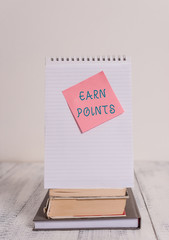 Writing note showing Earn Points. Business concept for getting praise or approval for something you have done Stacked books spiral note book sticky lying vintage retro wooden table