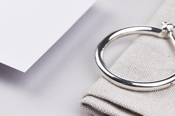 paper mockup silver jewelry lihgt grey cloth cotton flatlay detail 