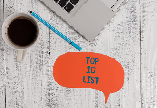 Text sign showing Top 10 List. Business photo showcasing the ten most important or successful items in a particular list Metallic open laptop speech bubble coffee cup ballpoint pen vintage table