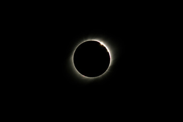 The Baily's beads effect and Diamond Ring effect during Total Solar Eclipse Chile 2019, amazing view of the Sun covered by the Moon during totality phase while the last sunbeams pass the Moon craters