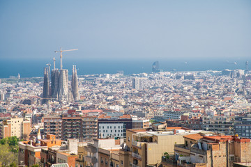 Obraz premium Barcelona, Hiszpania - kwiecień 2019: Widok na Barcelonę i linię brzegową wiosną z bunkrów w dzielnicy Carmel. Niewiele budynków wyróżnia się jak sagrada familia i wieża Agbar