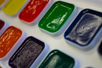 Multicolored watercolor paint in white box