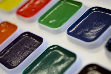 Multicolored watercolor paint in white box