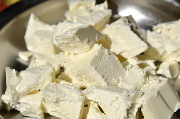 Sour milk cheese is cut into pieces lying on a platter.