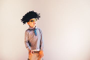 Child with rastafari wig dancing cheerful, isolated copy space white background.