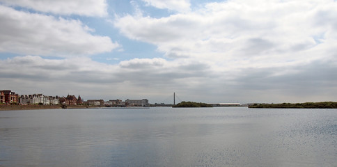Naklejka premium a wide panoramic view of the town of southport in merseyside from the sea with buildings along the waterfront and the bridge and pier in the distance
