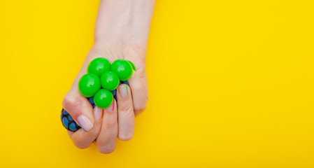 Fototapeta na wymiar Anti-stress toy in female hand on yellow background