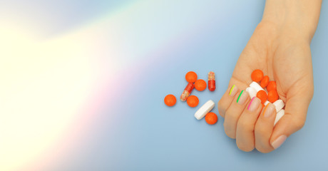 Female hands with beautiful modern manicure and pills with lights, healthy nails concept