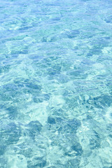 Close-up view of a transparent turquoise sea water that forms a natural texture, Emerald Coast, Sardinia, Italy.