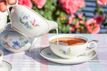 Tea in the English style on the background of roses