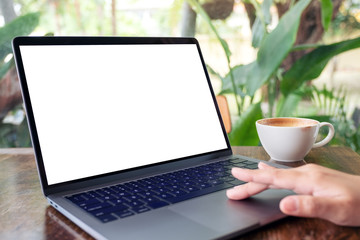 Mockup image of a woman using and touching laptop touchpad with blank white desktop screen on...