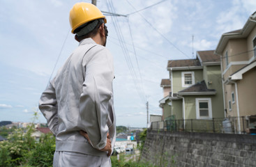 住宅街に立つヘルメットの男性　現地調査