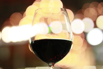 Glass of Red Wine with Warm Light Bokeh Background  
