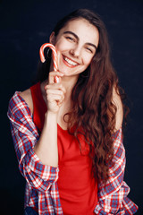 Obraz premium Beautiful girl in a room. Stylish girl in a red shirt. Lady with a candy