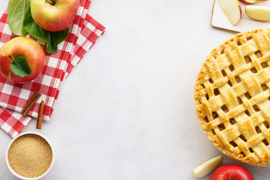 Homemade apple pie with lattice top and ingredients.