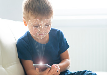 Kid using face id recognition. Boy with a smartphone gadget. Digital native children concept.