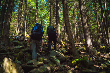 Two friends travel in the mountains with backpacks