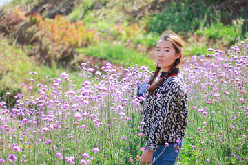 Asian woman wearing sunglasses in flower field