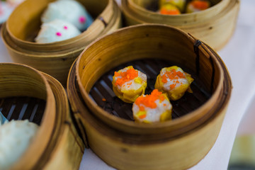 Dim sum, traditional Chinese dumplings, in bamboo steamer basket