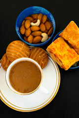 cup of tea, dry fruits and cake on wooden table