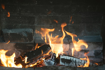 Burning firewoods in fire in a fireplace background.